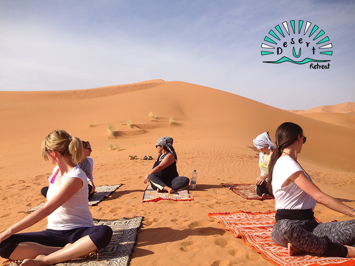 women practicing yoga in the sahara desert on a berber carpet, morocco