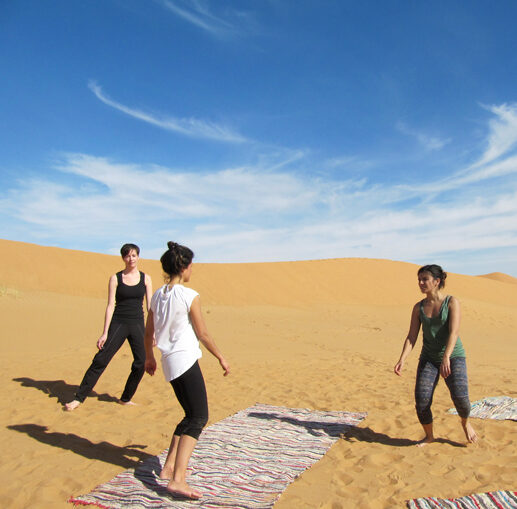 three women dancing in the sahara desert, morocco