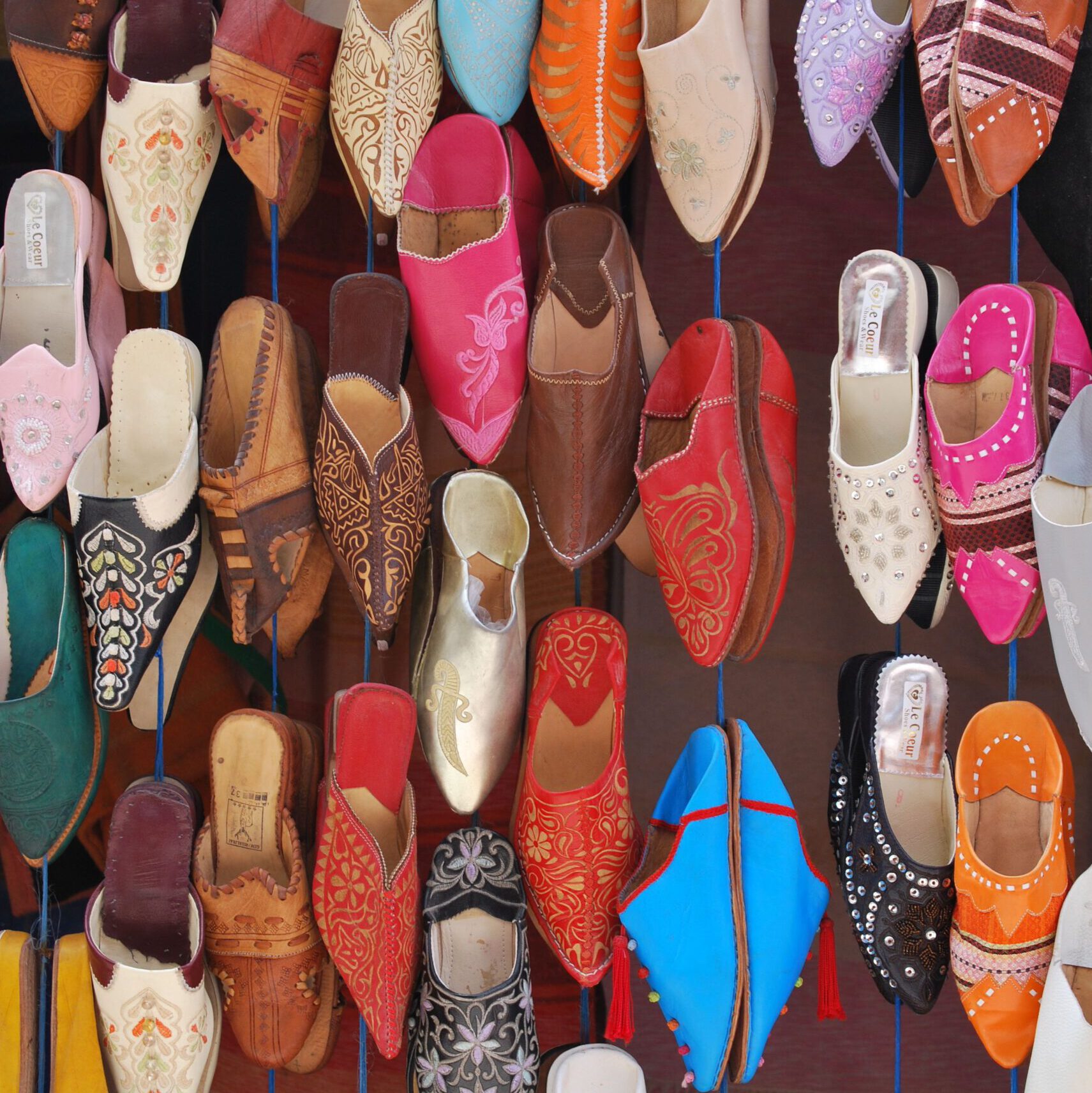 moroccan babouche shoes hanging down in many colors in the Souk