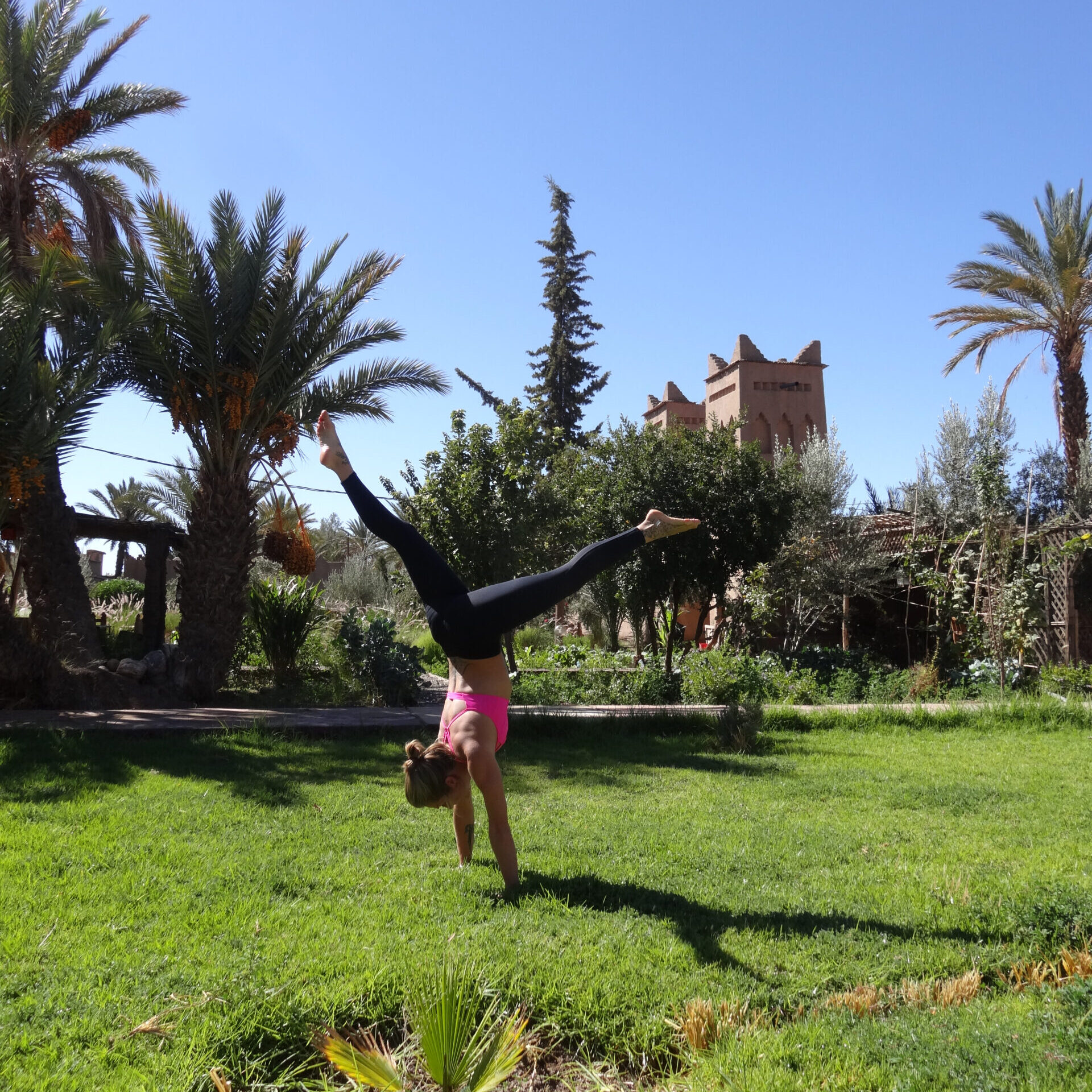 woman inhandstand on the grass in morocco