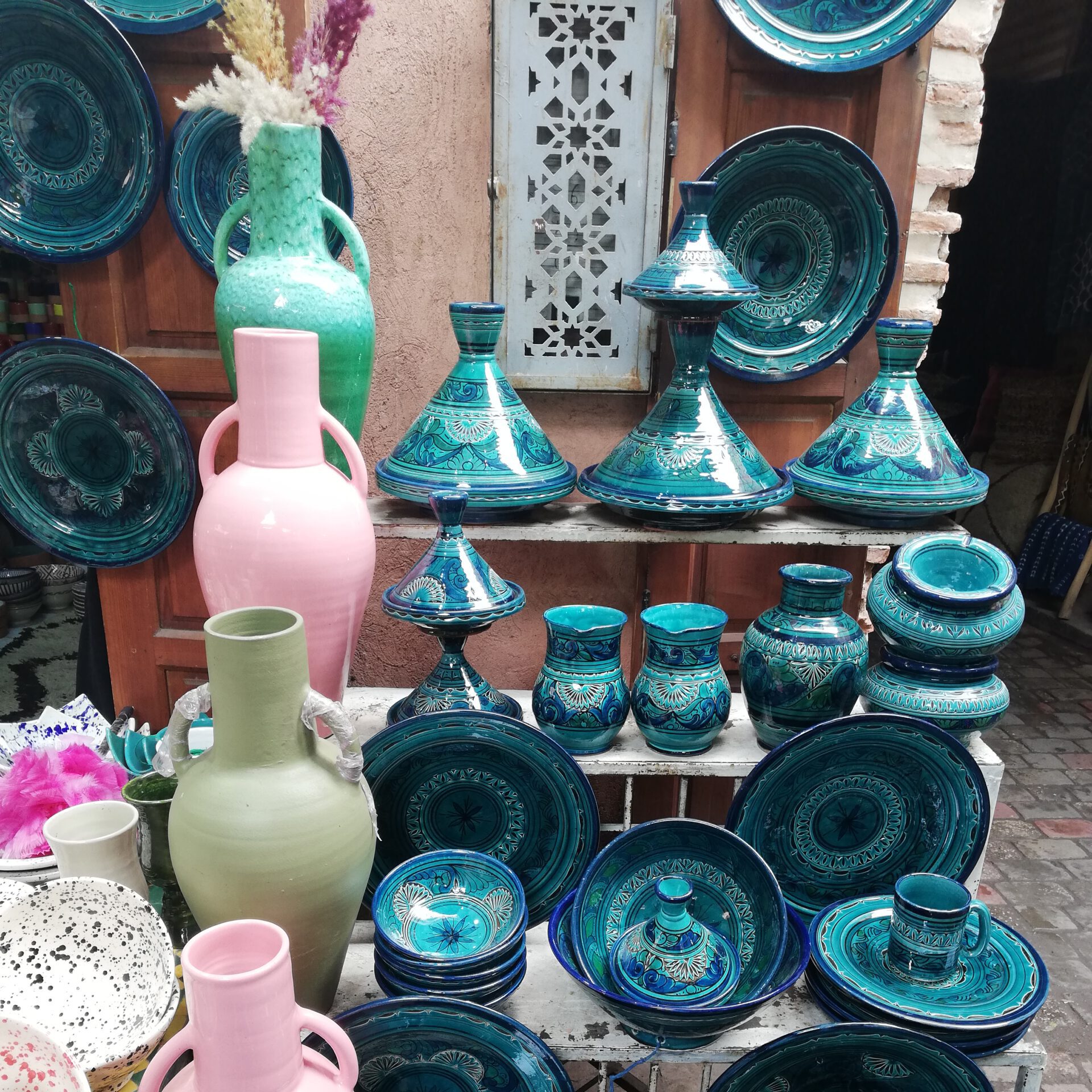 moroccan ceramics in the souk in marrakesh, green tajine ceramic pots, and pink and green vases