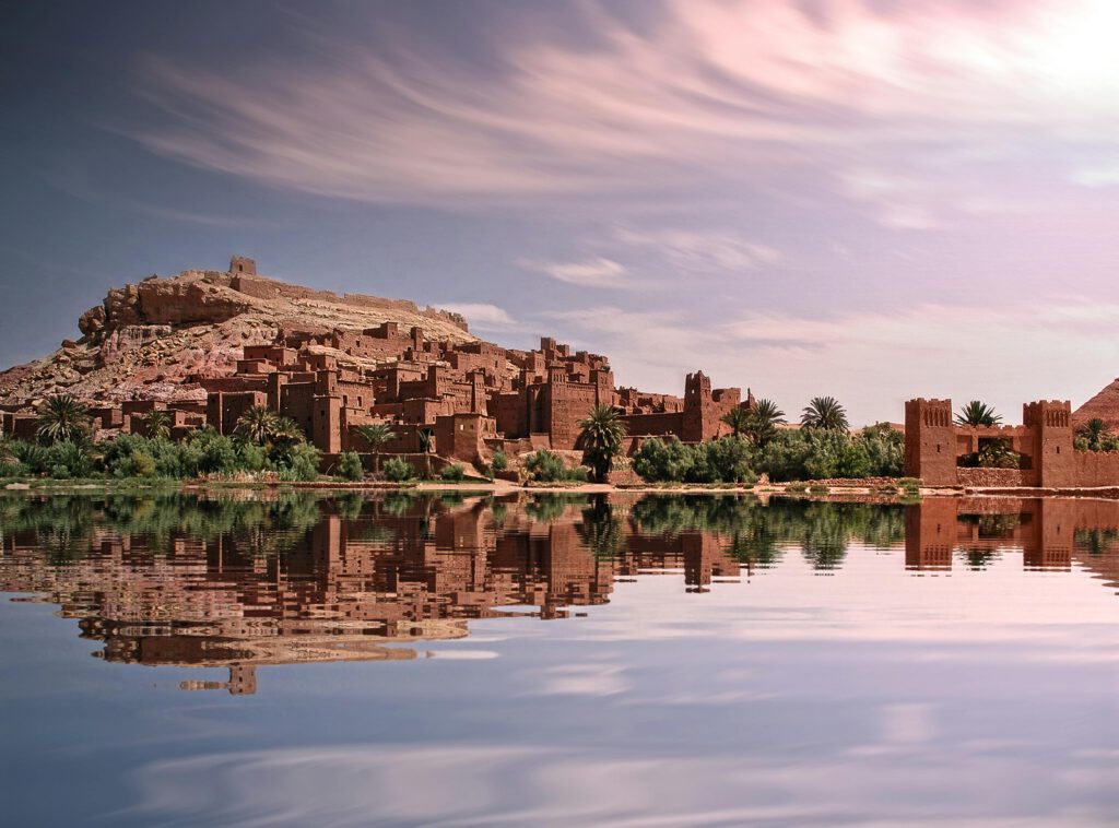 kasbah in front of a lake, mirroring in the water, morocco