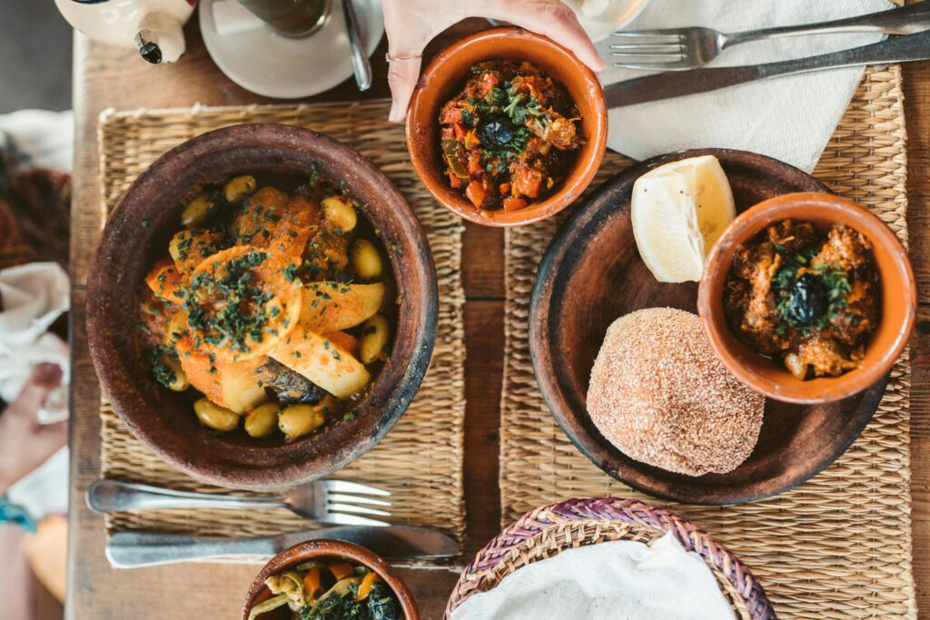 moroccan food in two tajine pots with morrocan round bread and antipasti of olives