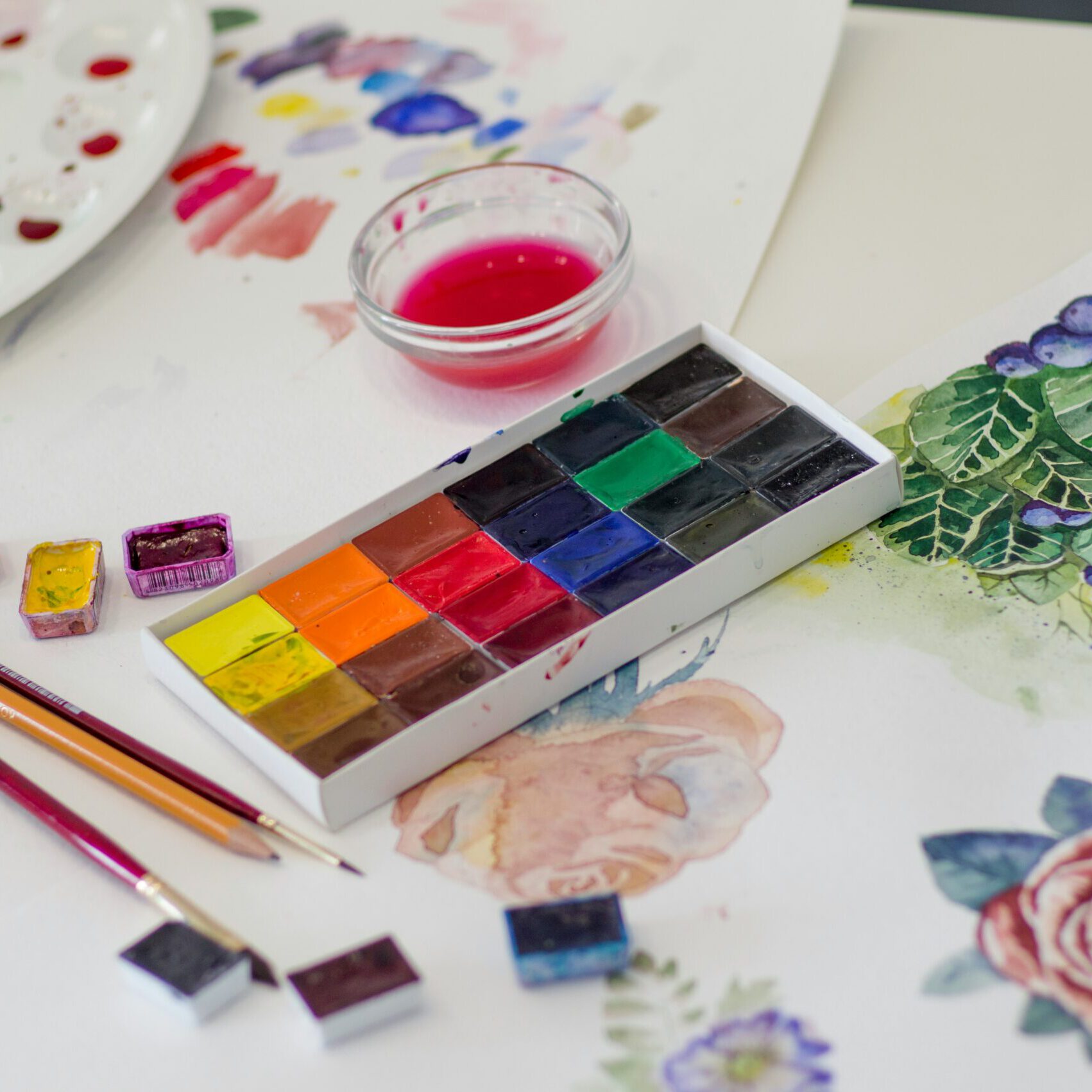 watercolor utensils, colors, pencils, palette, and painted roses